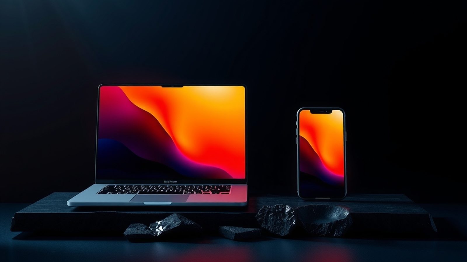 Siyah taş üstünde ekranları yanan dizüstü ve telefon